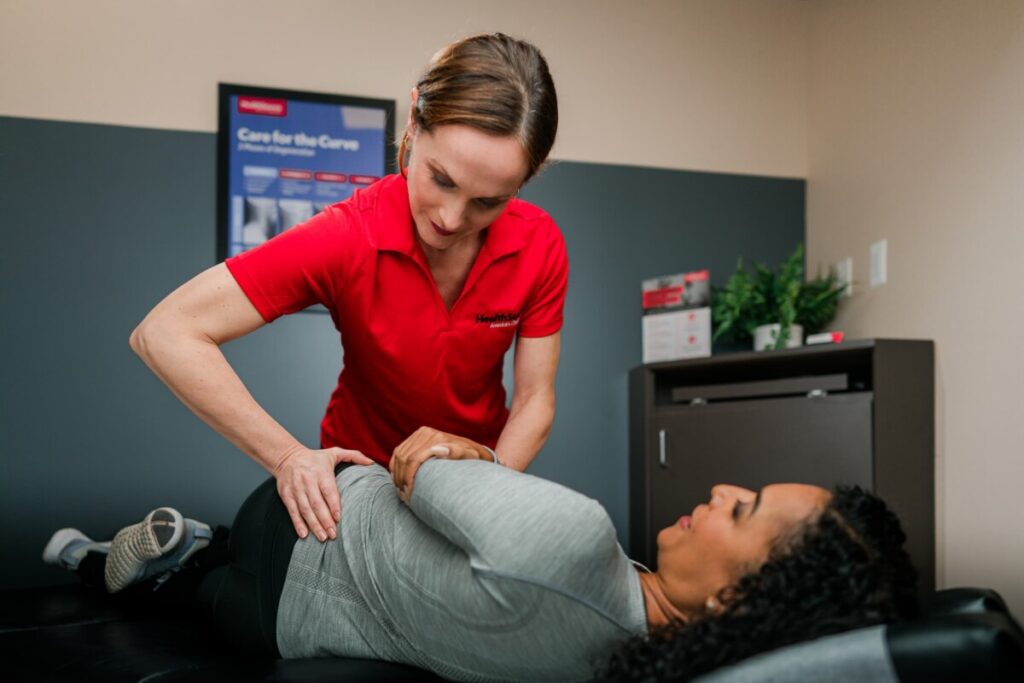 Patient lays on side as practitioner adjusts their lower back