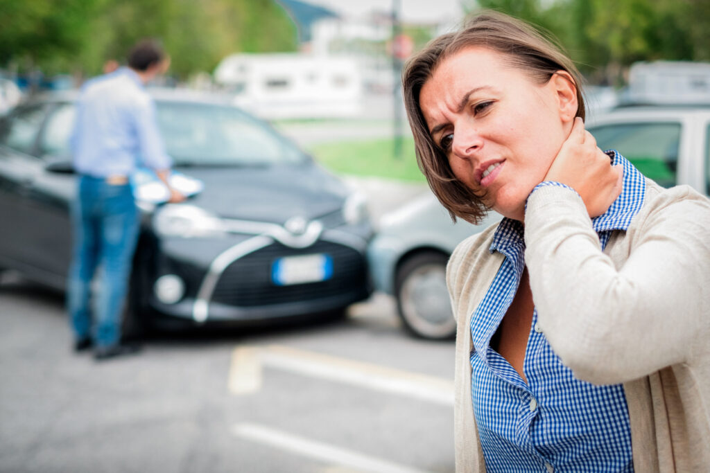 Woman feeling pain after car accident in the city.