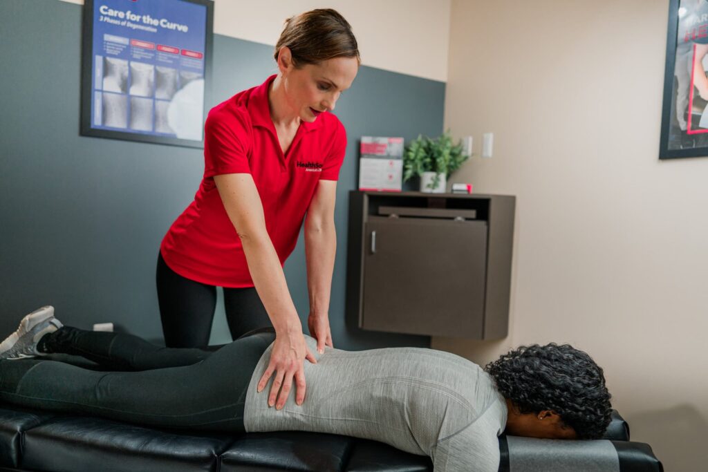 HealthSource chiropractor presses on a patient's lower back.