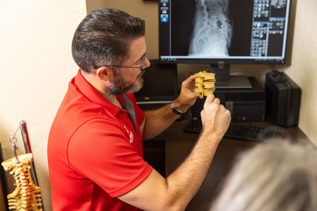 Dr. Jason Hunt reviewing spine x-rays with a patient.