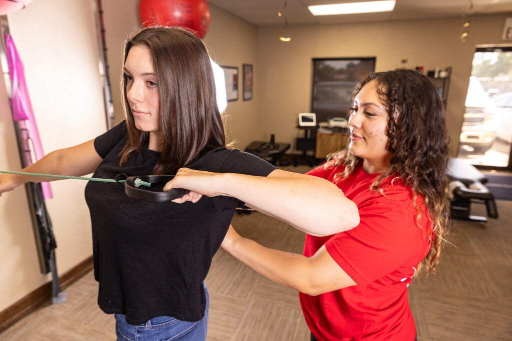 A rehabilitation specialist at HealthSource of Nederland working with a patient on strengthening the upper back and shoulders.