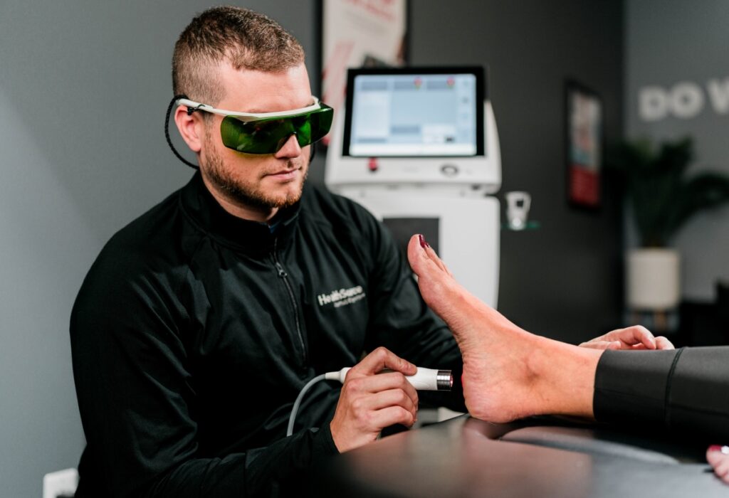 Dr. Cory Lamar treating a patients foot with Laser Therapy at HealthSource of Rocky River