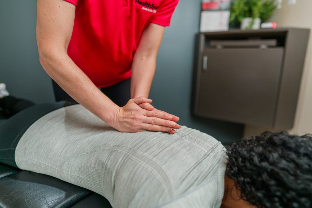 Close up of practitioner pressing down below a patient's shoulderblades.