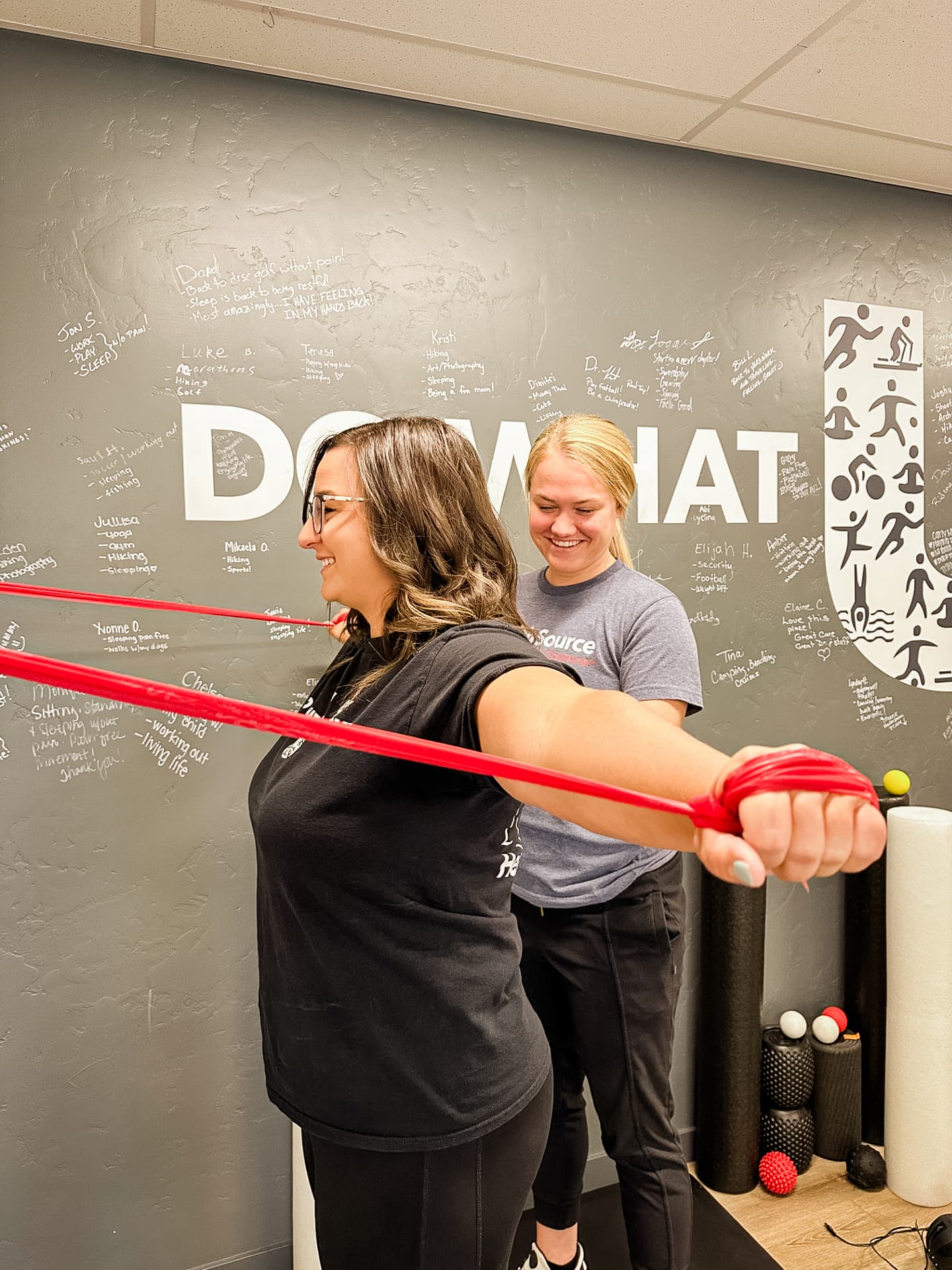 Patient pulls tension cords out, away from their body, as a practitioner guides them.