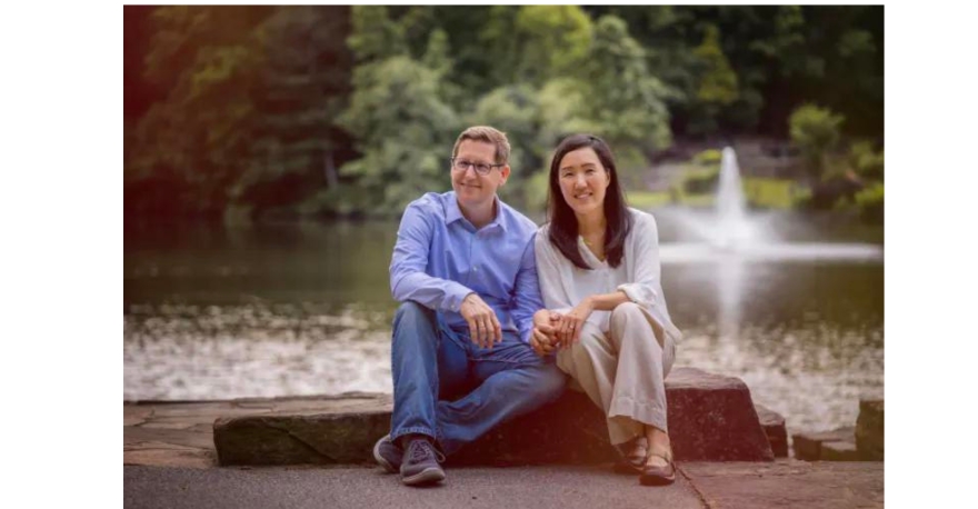 Dr. Adam Hayes and Dr. Karen Hayes of HealthSource of Cumming, posing together, holding hands near a lake.