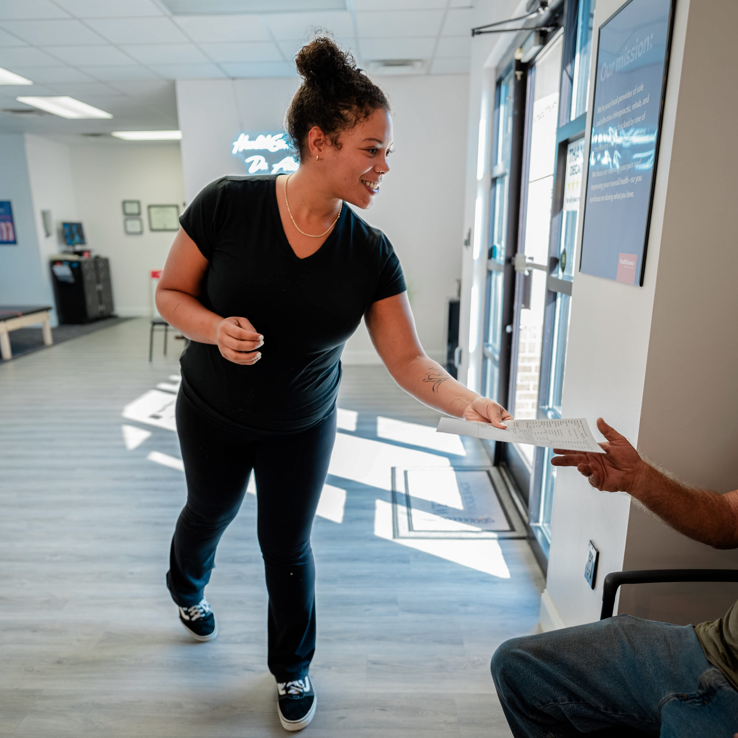 A practitioner passes pamphlets to a patient.