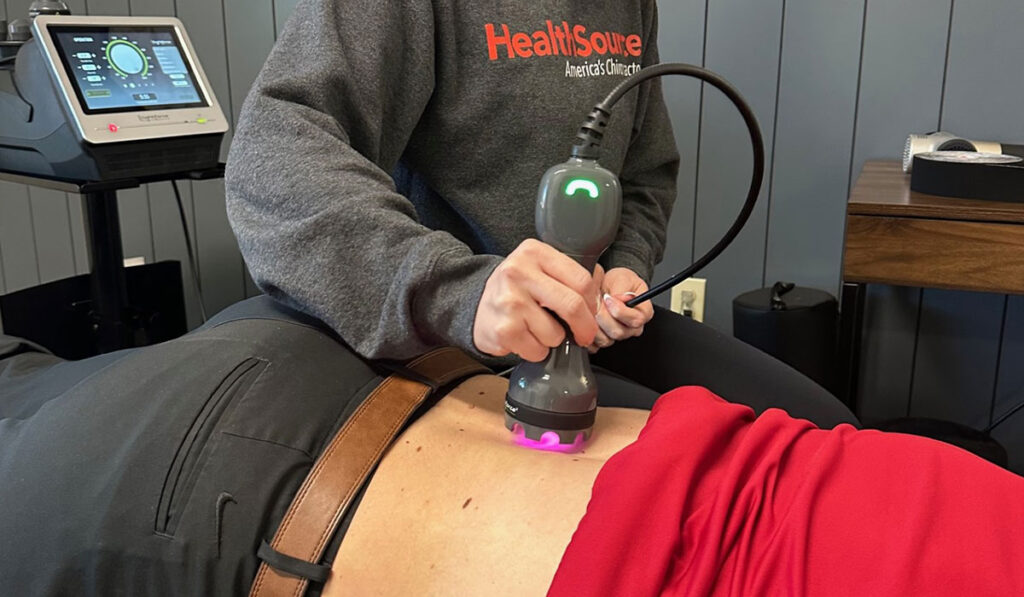 A patient receiving laser therapy treatment on their lower back at HealthSource of Meridian