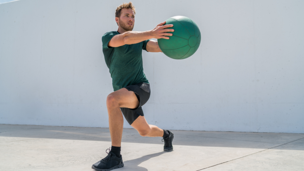 Man holding an exercise ball doing a lunging side bend to work on his core strength