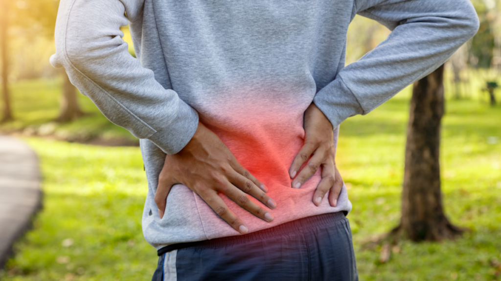 A person holding their lower back in discomfort, with a red glowing area highlighting the source of pain.