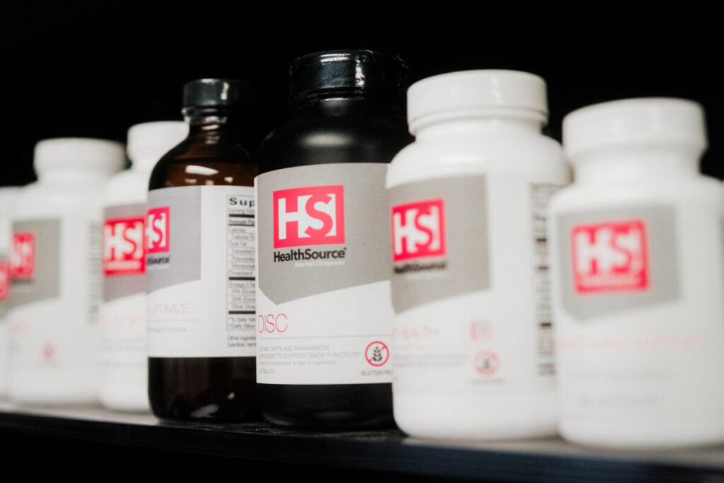 A row of HealthSource-branded supplement bottles on display