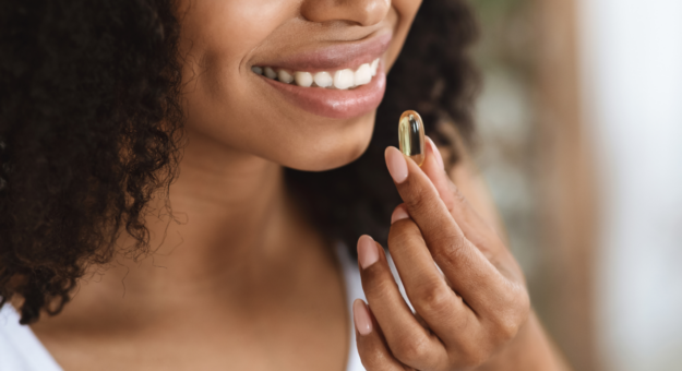 Woman smiling while taking a supplement