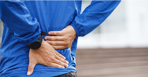 A man holding his lower back, appearing as though he might be in pain.